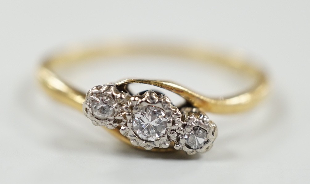 An 18ct & plat, three stone diamond set crossover ring, size T/U, gross weight 3.3 grams.